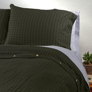 Moss checkered organic cotton and linen Pillow Sham Set shown on a bed.