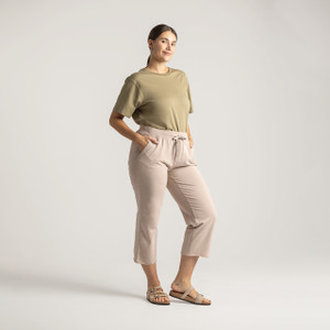 Full body view of model wearing cropped sweatpant in putty with hand on hip.