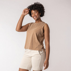 Front view of model wearing organic cotton sleeveless tee in turmeric.