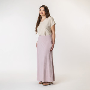 Full body side view of model wearing organic cotton maxi skirt in lavender.