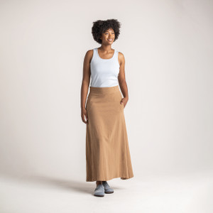 Full body front view of model wearing organic cotton maxi skirt in turmeric.