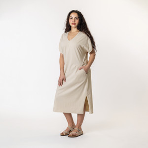 Side full body view of model wearing organic cotton kaftan dress in pearl.