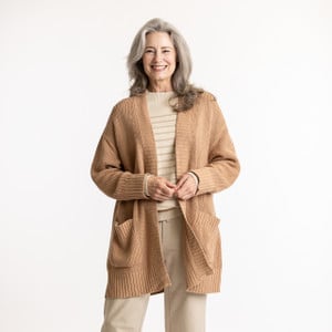 Front view of model with hands in pocket wearing organic cotton cardigan sweater in color turmeric