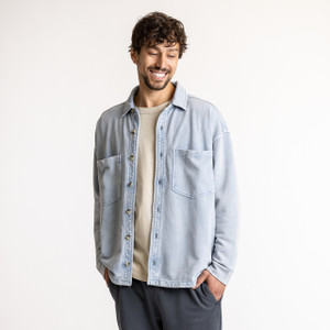 Front view of model wearing organic cotton workwear shirt in color denim blue.