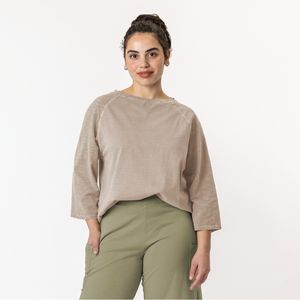 Close up front view of model wearing organic cotton 3/4 sleeve tee in color putty.