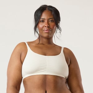 Front view of model wearing organic cotton ruched bralette in color natural.