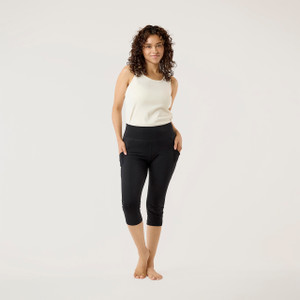 Model wearing black solid color organic cotton mid calf blackout leggings shown from the front.