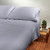 Steel Blue solid color organic cotton Sateen Sheet set put on a bed.
