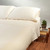 Natural solid color organic cotton Sateen Sheet set put on a bed.