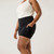 Close up side view of model wearing organic cotton blackout pocket leggings short with hand in pocket.