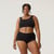 Front close up view of model wearing organic cotton essentials women's boyshort 2 pack in color black.