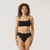 Close up front view of model wearing organic cotton essentials women's bikini 2 pak in color black.