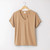 Front view of organic cotton slouch tee on a hanger in turmeric.