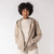 Front view of model wearing hooded cardigan in putty with hand in pocket.