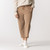 Front view of model wearing cropped sweatpant in turmeric with hand in pocket.