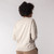 Back view of model wearing reversible fleece crew in pearl.