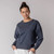 Front view of model wearing reversible fleece crew in infinity blue.