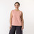 Front view of model wearing organic cotton sleeveless tee in blush.