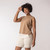 Front view of model wearing organic cotton sleeveless tee in turmeric.