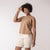 Front view of model wearing organic cotton sleeveless tee in turmeric.