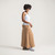 Full body side view of model wearing organic cotton maxi skirt in turmeric.