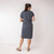 Back full body view of model wearing organic cotton kaftan dress in infinity blue.
