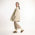 Full body side view of model wearing organic cotton cardigan sweater in color pearl