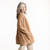 Side view of model with hands in pocket wearing organic cotton cardigan sweater in color turmeric