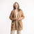 Front view of model with hands in pocket wearing organic cotton cardigan sweater in color turmeric