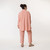 Full body back view of model wearing organic cotton button down shirt in color blush.