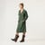 Full body side view of model wearing organic cotton workwear dress in color pine.