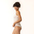 Close up side view of model wearing organic Cotton Women's Low-Rise Bikini in color natural.