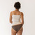 Close up back view of model wearing organic Cotton Women's Low-Rise Bikini in color sable.