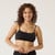 Front view of model wearing organic cotton strappy bralette in color black.