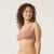 Side view of model wearing organic cotton ruched bralette in color clay.