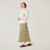 Full body side view of model wearing organic cotton turtleneck in color natural.