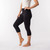 Side view of model wearing organic cotton base layer leggings midcalf in solid black.