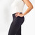 Model wearing black solid color organic cotton mid calf blackout leggings shown closeup from the side.