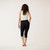 Model wearing black solid color organic cotton mid calf blackout leggings shown from the back.