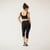 Model wearing black solid color organic cotton mid calf blackout leggings shown from the back.