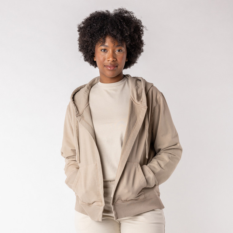 Front view of model wearing organic cotton hooded cardigan in putty with hand in pocket.