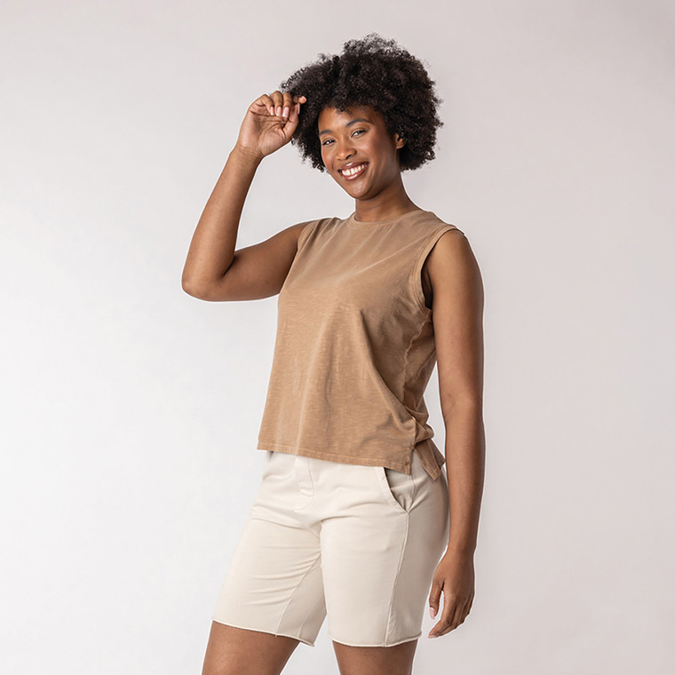 Front view of model wearing organic cotton sleeveless tee in turmeric.