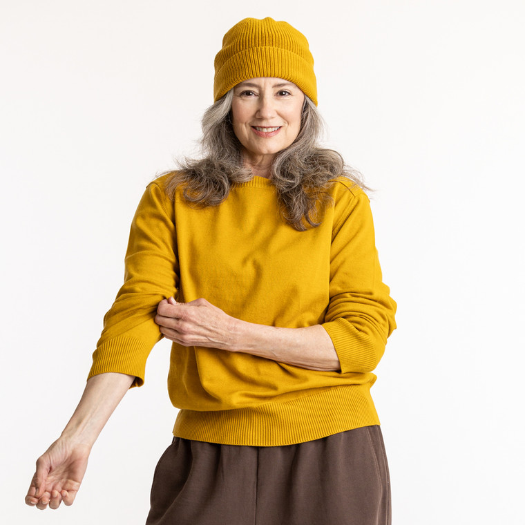 Model wearing organic cotton fisherman beanie in color gold
