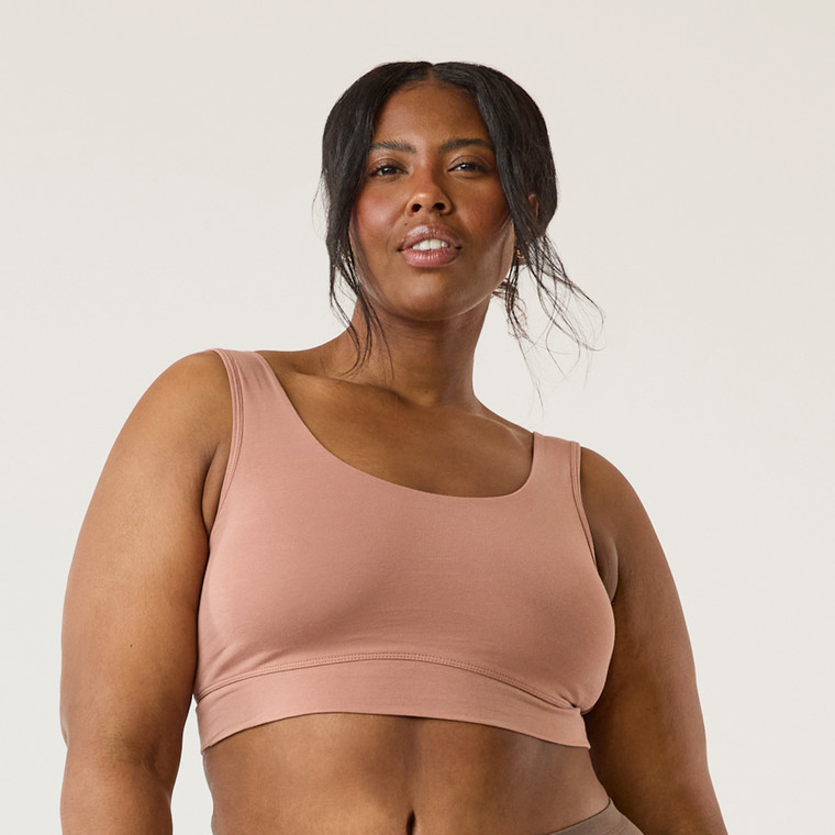 Front view of model wearing organic cotton scoop bralette in color clay.